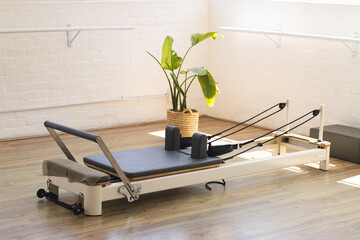 A Pilates reformer is ready for a workout in a bright studio