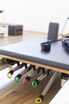 A Pilates reformer machine is ready for a workout in a bright studio