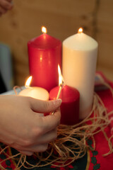 Hand lighting a set of colored candles 