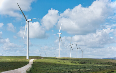Sustainable energy concept with windmills dotting a vibrant rural landscape under a blue sky - 751352963
