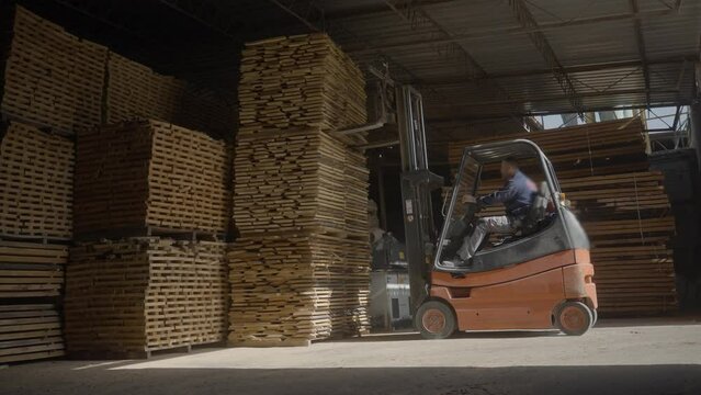 Skillful worker drives forklift in the warehouse