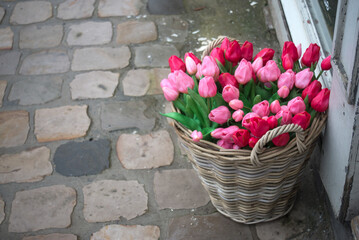 closeup of red and pink  tulips bouquet in a wooden basket at the florist in the street - 751357912