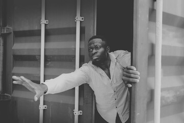 Black and white photos stateless, unidentified black man hiding shipping container trying escape...