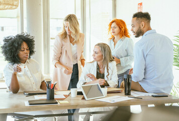 Businesswoman talking to her colleagues while gathering in the meeting room.
