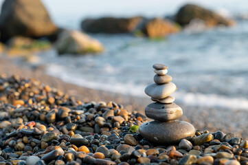 Pyramid of sea pebbles on the seashore. Zen relaxation and meditation concept