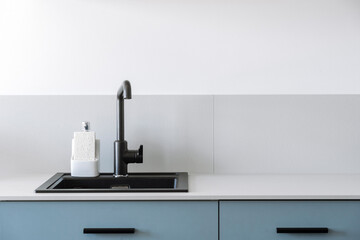 Blue kitchen cabinet with built in sink, sponge holder and dishwashing soap