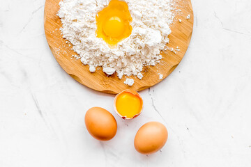Making dough concept. Pile of flour and eggs on white background top view space for text