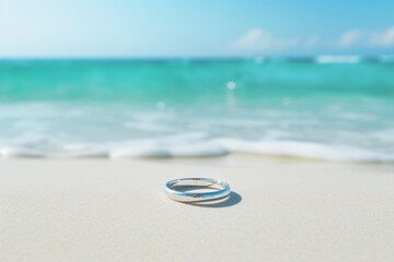 Wedding rings on the beach with sea and blue sky background with copy space.