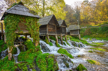 Old small wooden water mills called Mlincici built on Pliva lake near Jajce, Bosnia and...