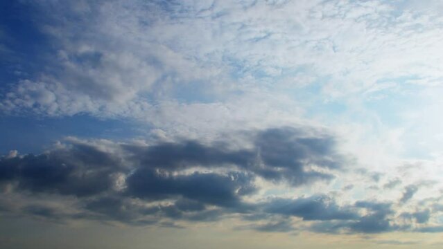 Clouds at different heights move in different directions. An unusual atmospheric phenomenon. The sky at sunset with a pink tint.