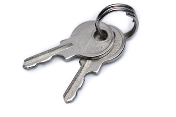 Dwa srebrne klucze do domu leżą izolowane na białym tle, wynajem mieszkania