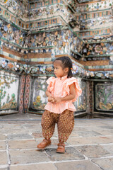 Toddler kindergarten girl wear Thai style costume travel in Wat Arun buddhist temple sightseeing travel