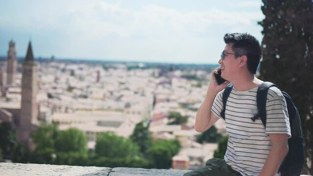 Happy young Asian tourist man selfie by mobile smartphone, Male traveller taking photo, recording vlog on holiday vacation trip at italy.