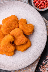 Delicious fresh crispy chicken nuggets on a dark concrete background