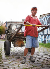 Man, portrait and cart for trash in street for smile, walk and collect garbage for recycling for...