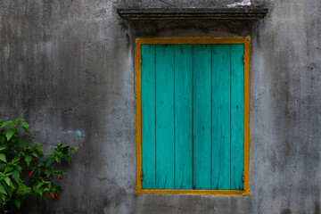 Turquoise blue wooden shutter on a window of a rural home in northern Vietnam.