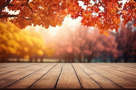 An empty wooden table top against the background of autumn leaves.