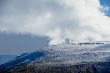 Welsh mountain winter landscape. Snow on the top of the mountains above Storey Arms in the Brecon Beacons.  Icy conditions but the sun is shining and has melted the snow of the foothills.