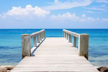 Selbstklebende Fototapeten a wooden dock with railings leading to the ocean © White