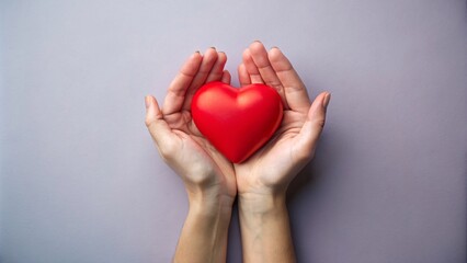 Female hands hold a red heart on a colorful background. The concept of love and health.