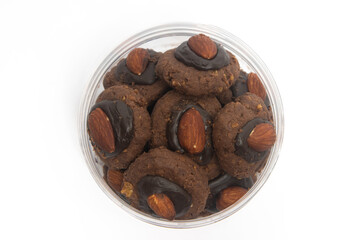 Afghan cookies made from chocolate and cornflakes with almond on top in a jar top view isolated on white background clipping path