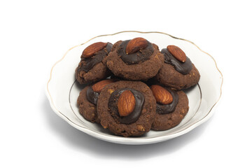 Afghan cookies made from chocolate and cornflakes with almond on top in a small white plate isolated on white background clipping path