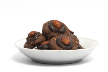 Afghan cookies made from chocolate and cornflakes with almond on top in a small white plate isolated on white background clipping path