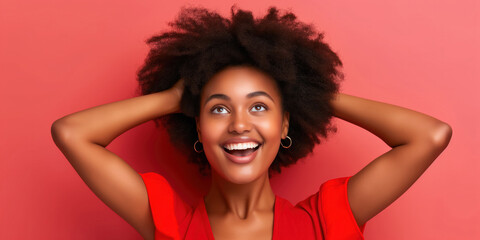 Joyful Young Woman Smiling with Hands in Hair Against Pink Background, copy space