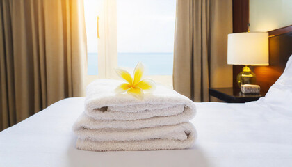 Fresh towels on bed in hotel room