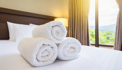 Fresh towels on bed in hotel room