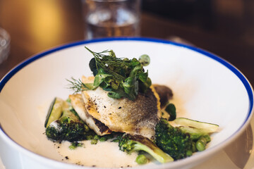 Sea bass fish fillet with grilled green vegetables and citrus sauce
