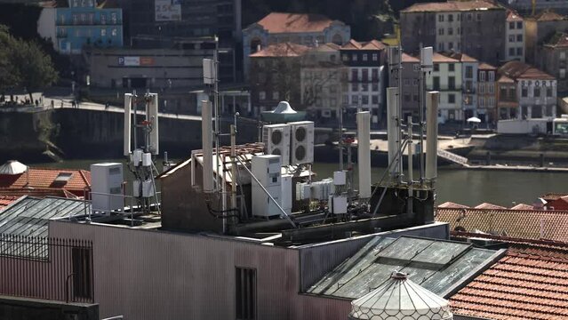 GSM communication antennas on a building roof in the middle of a city. Voice and internet 4G and 5G communication infrastructure industry. 4k video.