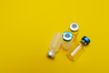 photo of several vials of injection medicine isolated on yellow background