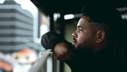 Introspective South American Young Man Gazing from Balcony - Deep Mental Reflection of 20s Black...