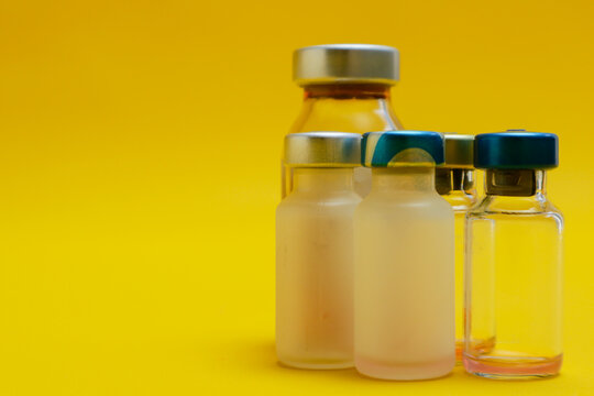 photo of several vials of injection medicine isolated on yellow background