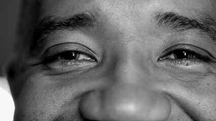 Macro close-up of a senior middle-aged man eyes with wrinkles and mouth smiling, person of African...
