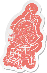 funny cartoon distressed sticker of a cat wearing santa hat