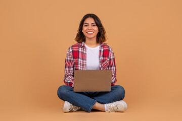 Young arabic woman holding and using laptop computer