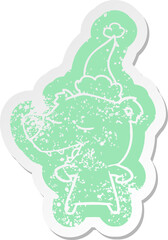 cartoon distressed sticker of a bear wearing santa hat
