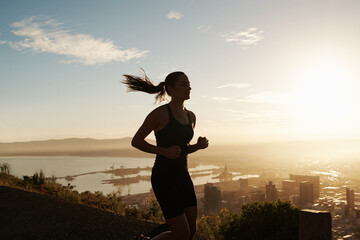 Fitness, running and woman on hill at sunset for health, wellness and strong body development....