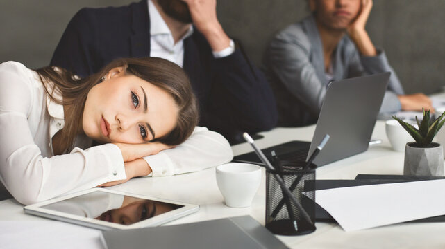 Boring presentation. Young business people looking bored