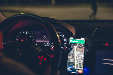 Close-up, steering wheel and navigator in a car at night.