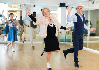 Fototapeta na wymiar Mature woman dancing swing with young man