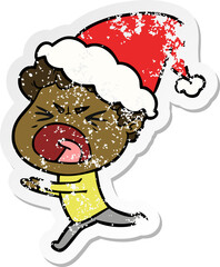 distressed sticker cartoon of a furious man wearing santa hat