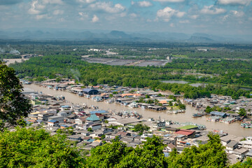 Fototapeta premium View of a River-side village, surrounded by Jungle and Mountains, in Thailand