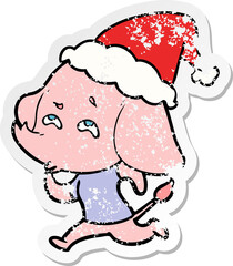 distressed sticker cartoon of a elephant remembering wearing santa hat
