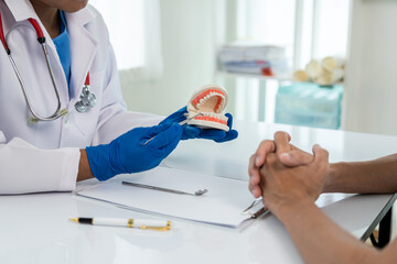 Dentist consultation - patient visit at the dental clinic office. Female dentist wearing dentures...