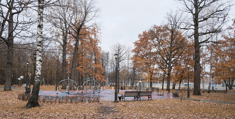 area with abstract figures and benches in an autumn park