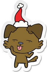 sticker cartoon of a dog sticking out tongue wearing santa hat