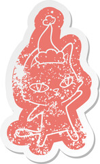 cartoon distressed sticker of a cat staring wearing santa hat